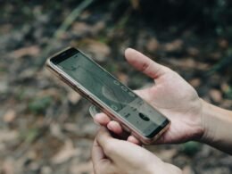 Nahaufnahme einer Person, die ein Smartphone in der Hand hält, Fokus auf moderne mobile Technologie und digitales Arbeiten
