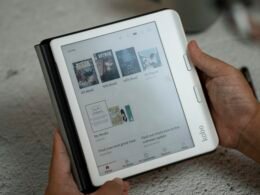 Eine Person hält ein Tablet in den Händen, auf dessen Bildschirm eine Webseite angezeigt wird, Fokus auf digitale Nutzung.