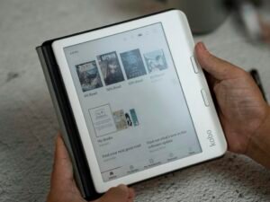 Eine Person hält ein Tablet in den Händen, auf dessen Bildschirm eine Webseite angezeigt wird, Fokus auf digitale Nutzung.