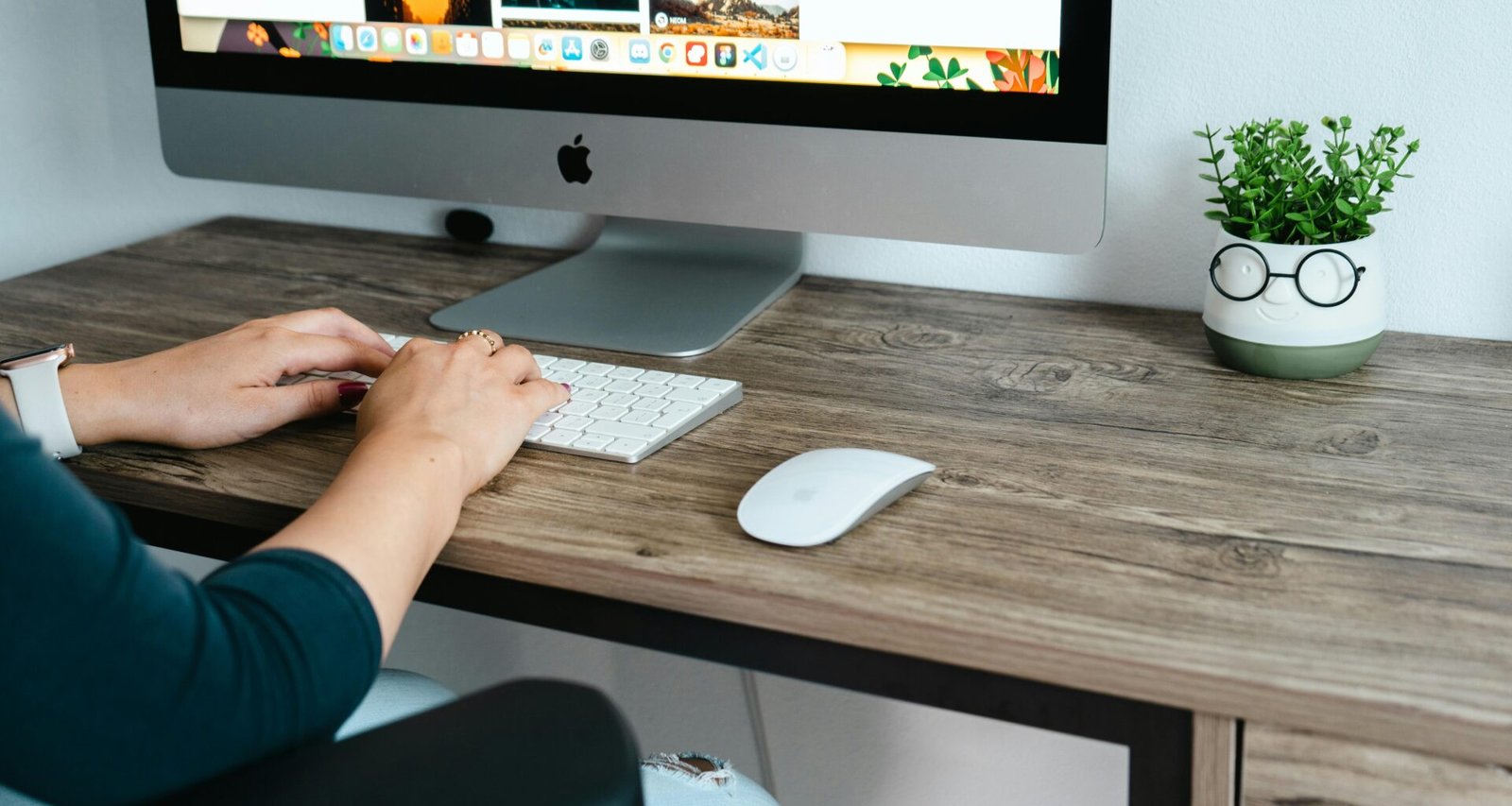 Eine Person sitzt an einem Schreibtisch mit Computer und arbeitet fokussiert in einem modernen Büro.