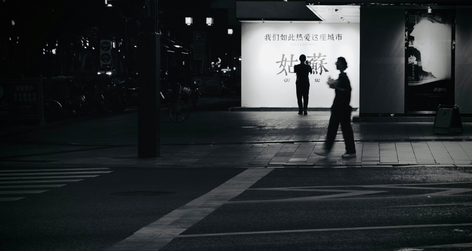 Eine Person läuft bei Nacht eine leere, von Straßenlaternen beleuchtete Straße entlang