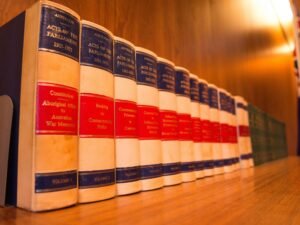 Mehrere Bücher stehen nebeneinander auf einem Holztisch und spiegeln den Zugang zu Wissen und Information wider.