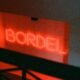 Leuchtendes rotes Neonzeichen mit dem Schriftzug bordil an einer Wand, fotografiert bei Nacht