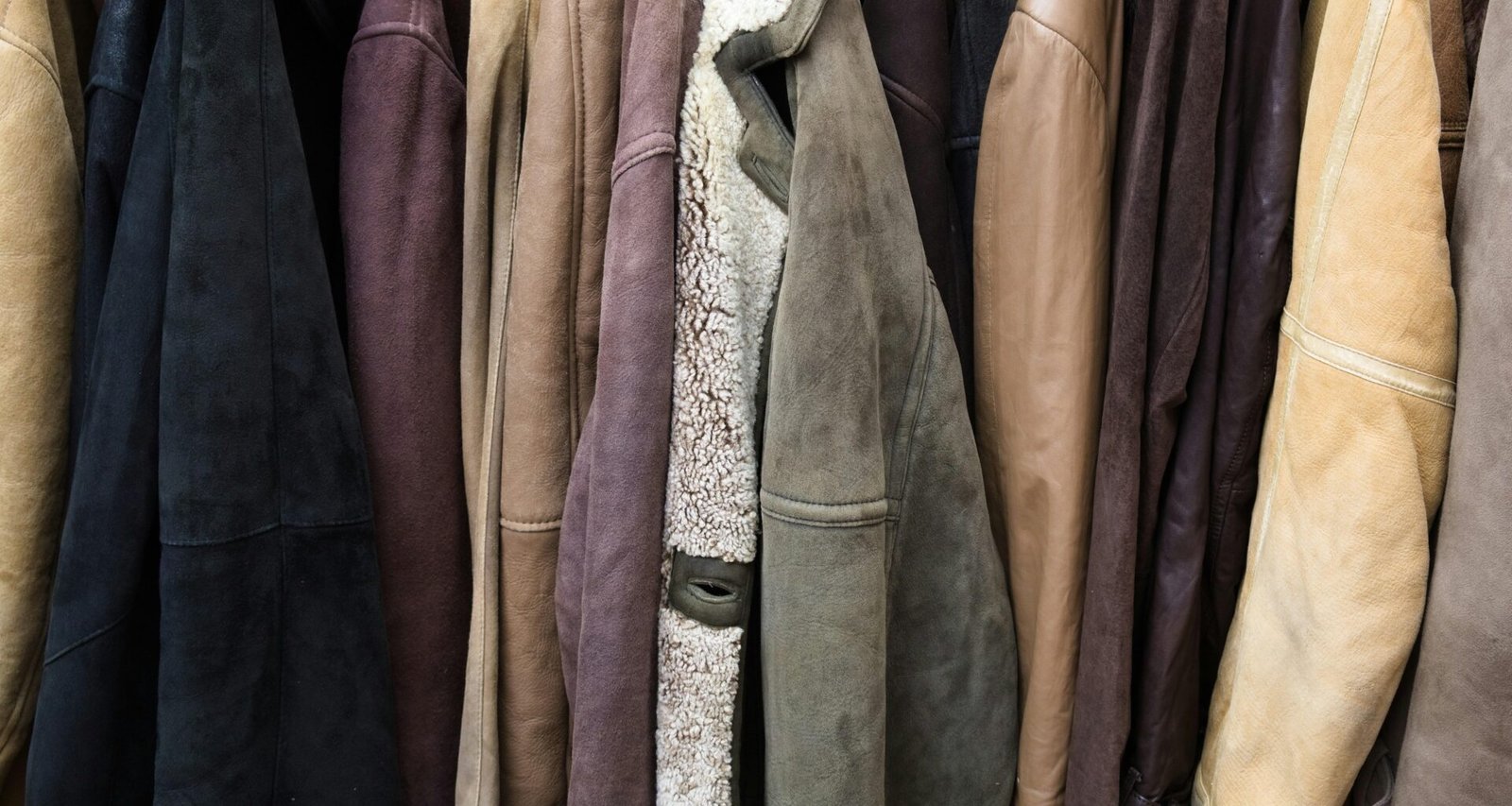 Verschiedene Lederjacken aus unterschiedlichen Materialien hängen nebeneinander an einer Kleiderstange
