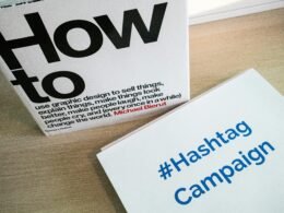 Eine Box mit der Aufschrift Hashtag Campaign steht auf einem Tisch und stellt Social-Media-Marketing dar.