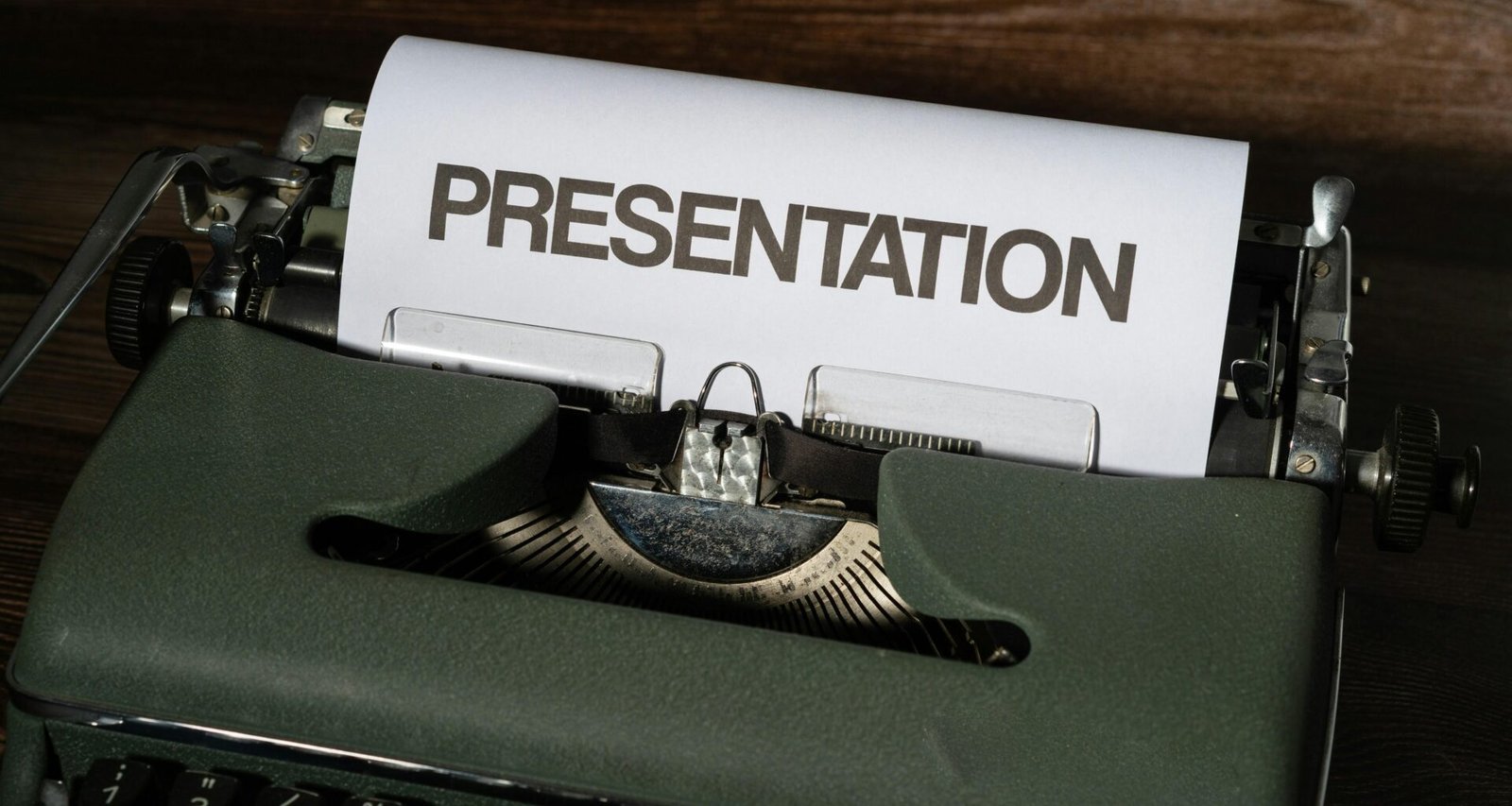 Eine alte Schreibmaschine mit einem angebrachten Schild darauf, fotografiert in Nahaufnahme auf einem Schreibtisch