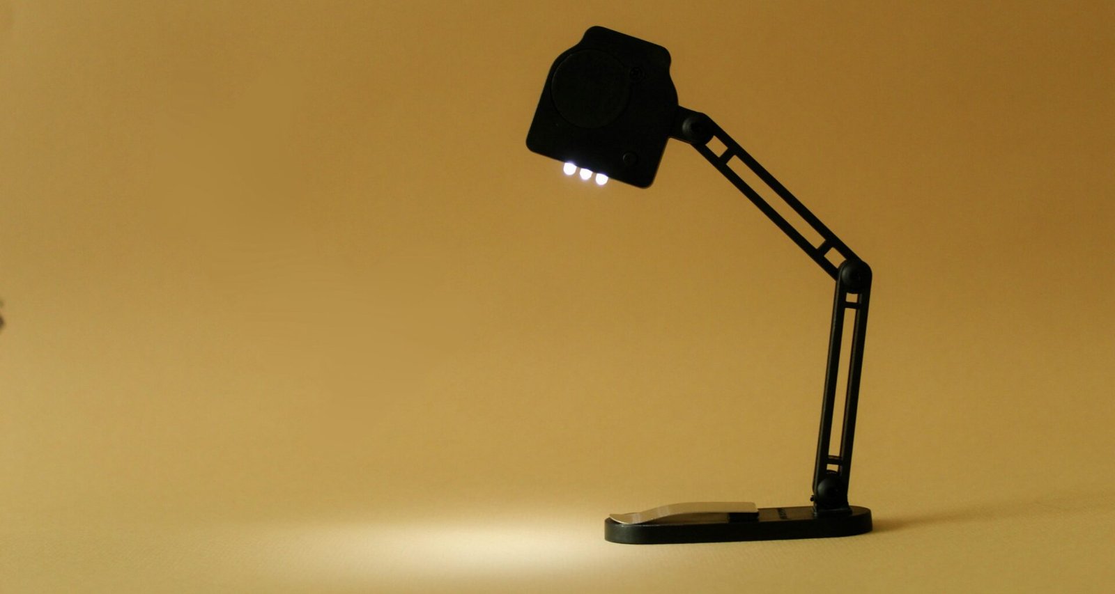 Schwarze Schreibtischlampe auf gelbem Hintergrund, minimalistisches Design für moderne Arbeitsräume