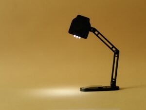 Schwarze Schreibtischlampe auf gelbem Hintergrund, minimalistisches Design für moderne Arbeitsräume