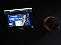 Ein Tablet liegt auf einem Tisch, daneben eine einzelne Münze – Fokus auf digitale Zahlungstechnologien.