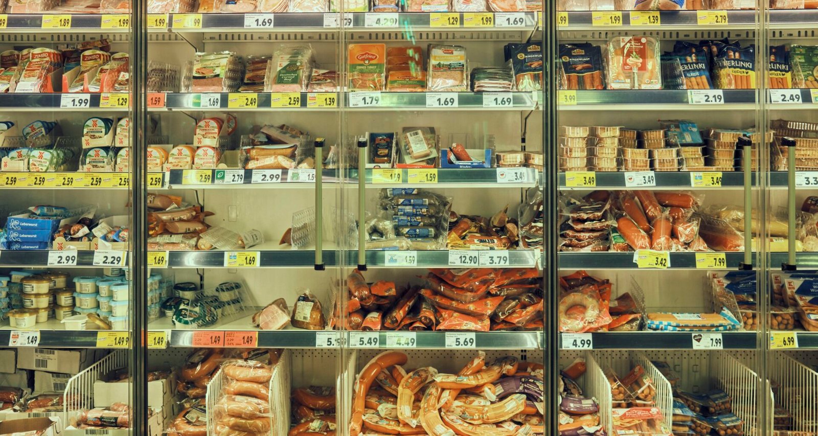 Eine moderne Verkaufsvitrine gefüllt mit zahlreichen verschiedenen Speisen, die nebeneinander präsentiert werden.