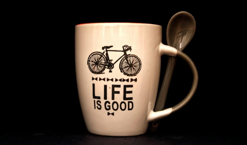 Weiße Kaffeetasse mit Löffel auf einem Tisch, minimalistisches Design, ideal als Bild für Pausen und Büroalltag