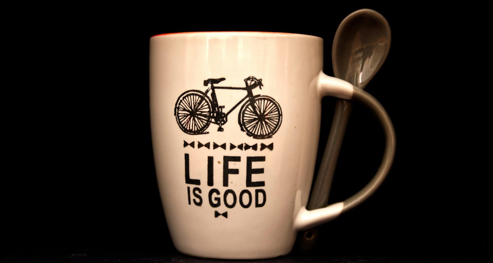 Weiße Kaffeetasse mit Löffel auf einem Tisch, minimalistisches Design, ideal als Bild für Pausen und Büroalltag