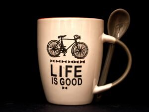 Weiße Kaffeetasse mit Löffel auf einem Tisch, minimalistisches Design, ideal als Bild für Pausen und Büroalltag