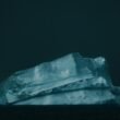 Großer weißer Eisberg treibt auf dunklem Wasser, aufgenommen von Matthew Stephenson, klare Struktur und kalte Farben