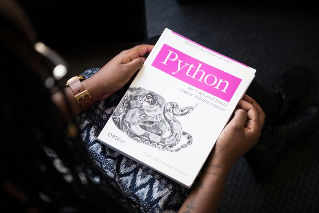 Schräg fotografiertes Python-Buch in Nahaufnahme auf einem Tisch, Fokus auf den Buchtitel, Umgebung unscharf dargestellt