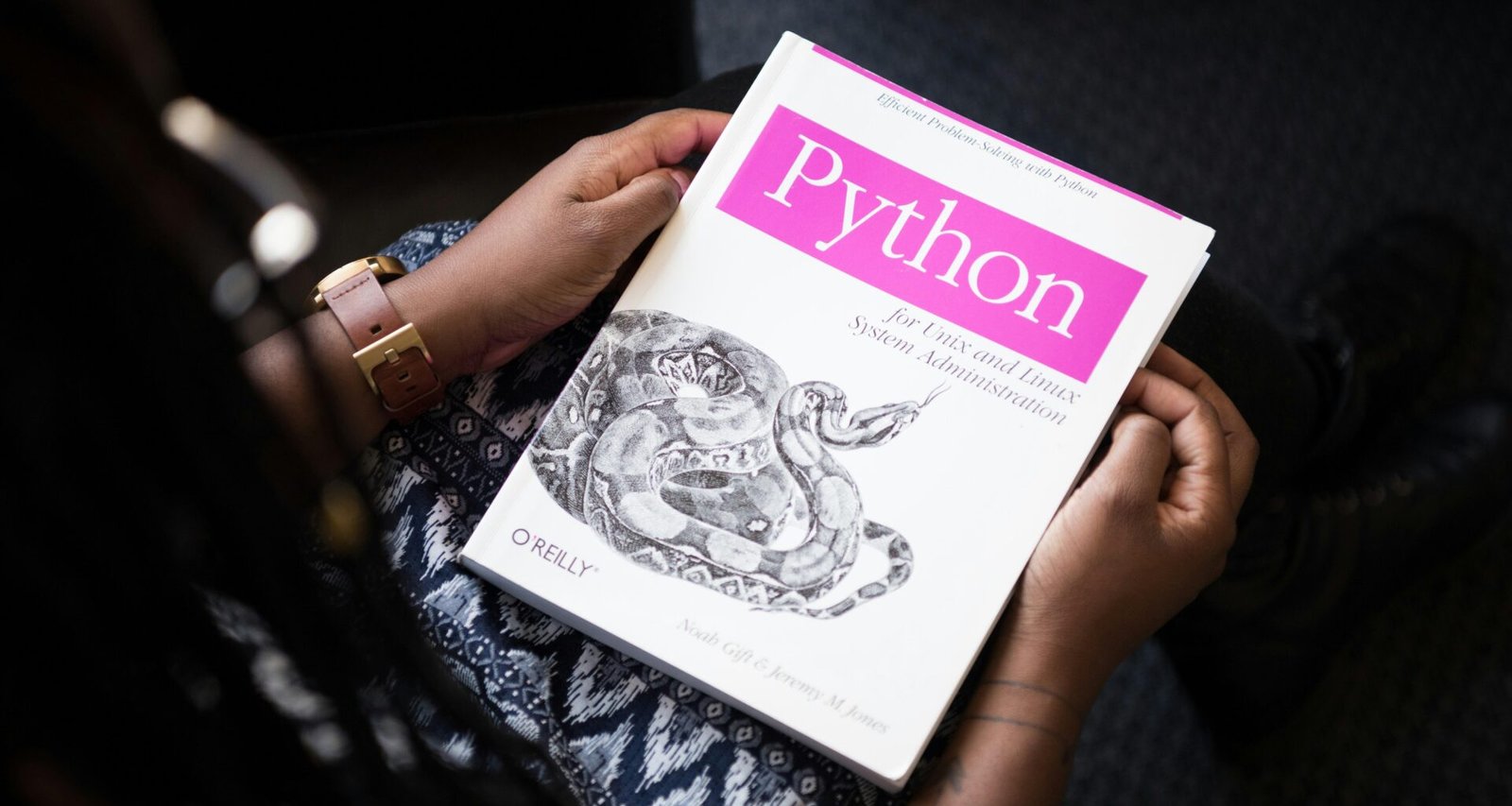 Schräg fotografiertes Python-Buch in Nahaufnahme auf einem Tisch, Fokus auf den Buchtitel, Umgebung unscharf dargestellt