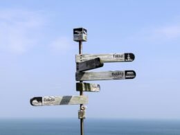 Graues Schild aus der Nähe fotografiert, unscharfer Hintergrund, Fokus auf klaren Linien und moderner Gestaltung.