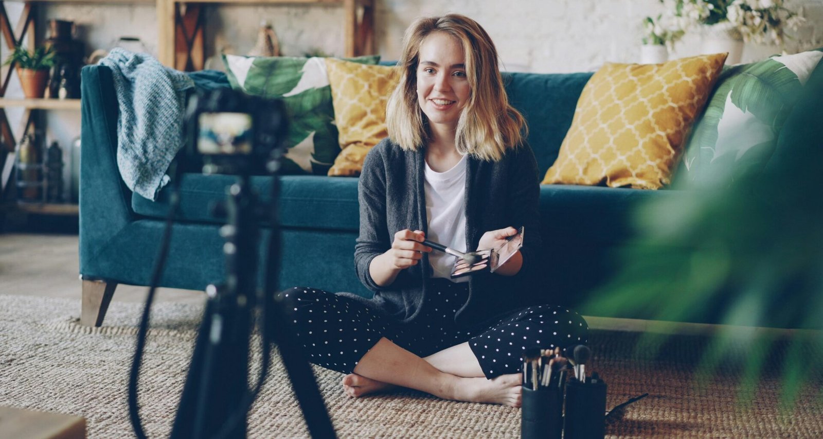 Frau filmt mit moderner Kamera in einem gemütlichen Wohnzimmer, geeignet für Content-Erstellung oder Livestreaming