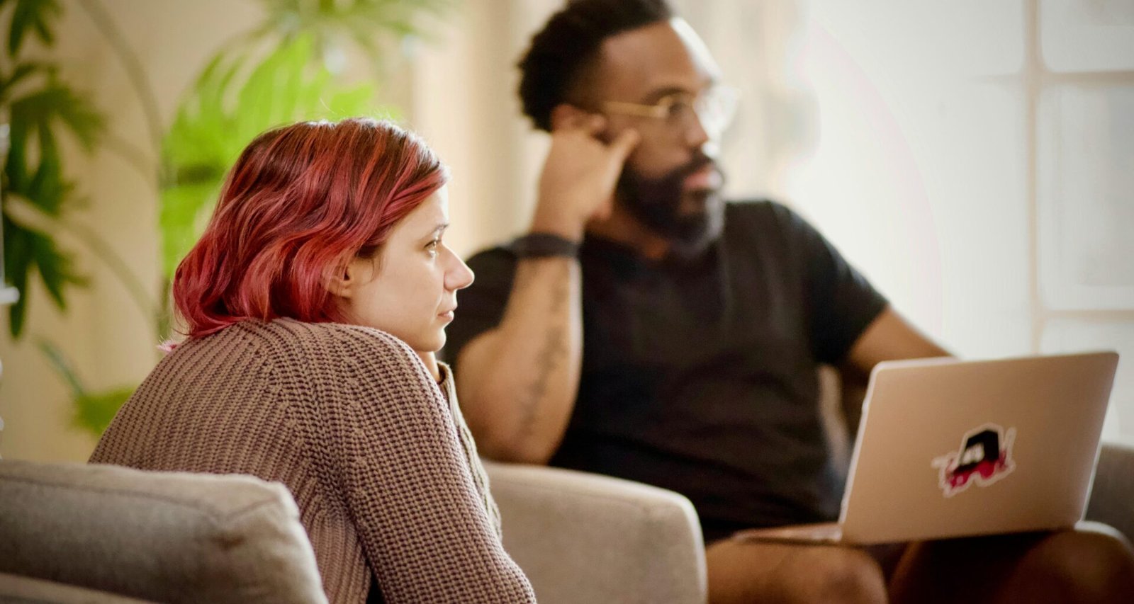 Frau mit schwarzem Shirt sitzt auf braunem Stuhl an einem Schreibtisch in einem modernen Büro