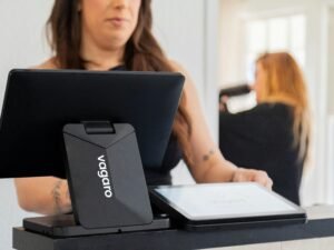 Frau verwendet ein Tablet an einem Kassentresen für die digitale Abwicklung von Bezahlvorgängen im Geschäft