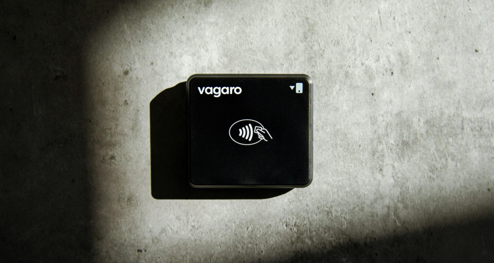 Ein quadratischer Kreditkartenleser liegt auf einer glatten Oberfläche und präsentiert moderne Zahlungstechnologie.