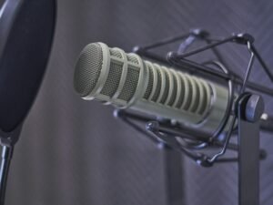 Graues Kondensatormikrofon mit Popschutz, ausgerichtet für hochwertige Audioaufnahmen im Studio oder Homeoffice.