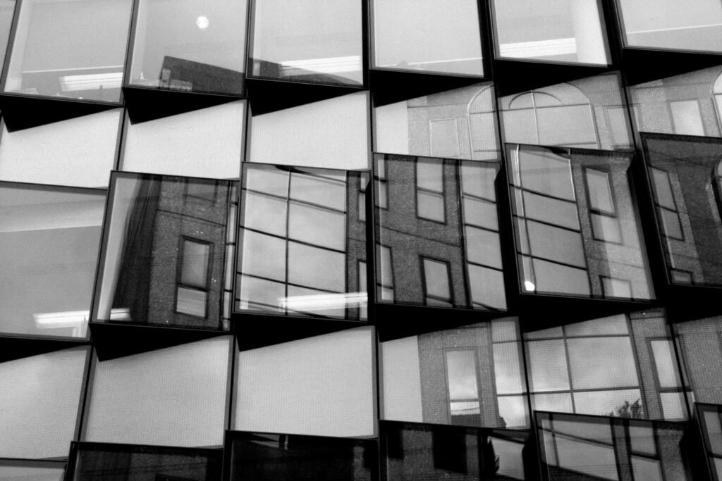 Schwarzweißfoto eines Fensters mit klaren Linien und moderner Architektur, fotografiert aus einem interessanten Blickwinkel