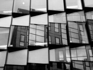 Schwarzweißfoto eines Fensters mit klaren Linien und moderner Architektur, fotografiert aus einem interessanten Blickwinkel