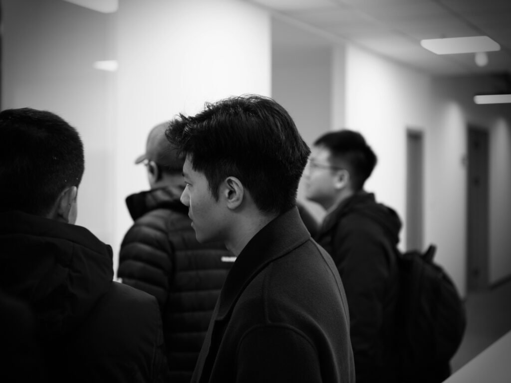 Mehrere Personen stehen und unterhalten sich in einem modernen, gut beleuchteten Büroflur.