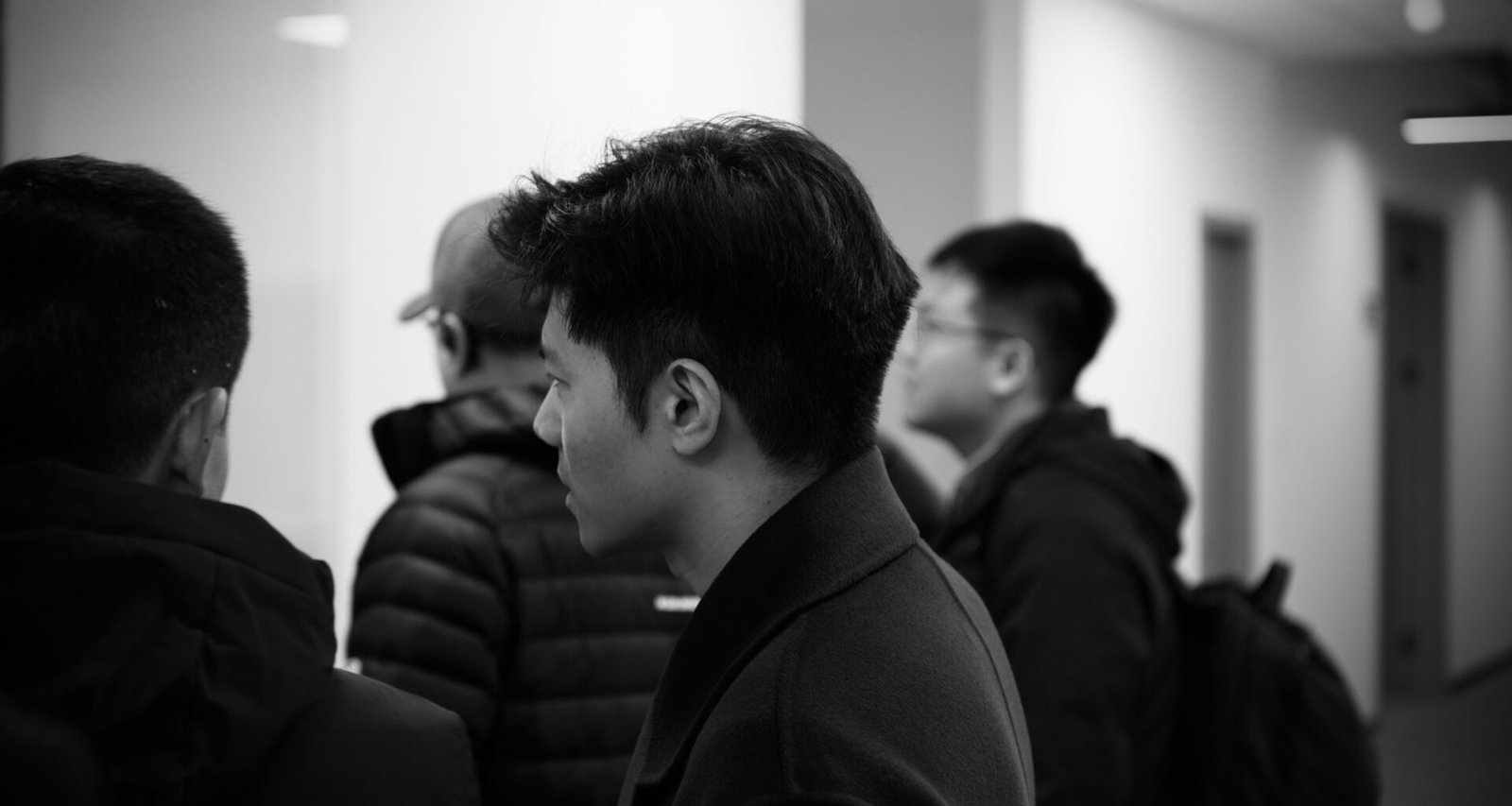 Mehrere Personen stehen und unterhalten sich in einem modernen, gut beleuchteten Büroflur.