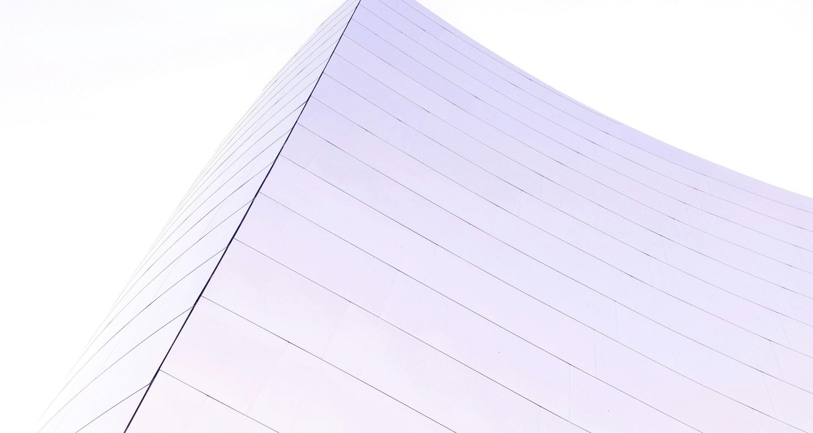 Modernes Hochhaus mit Glasfassade, aufgenommen aus Untersicht, als Beispiel zeitgemäßer Architektur in der Großstadt