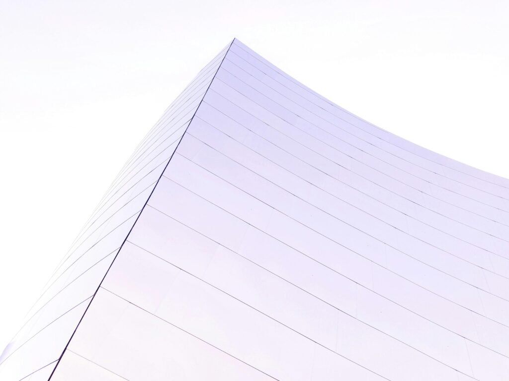 Ein hoch aufragendes modernes Gebäude mit Glasfassade, fotografiert aus der Froschperspektive in einer Großstadt.