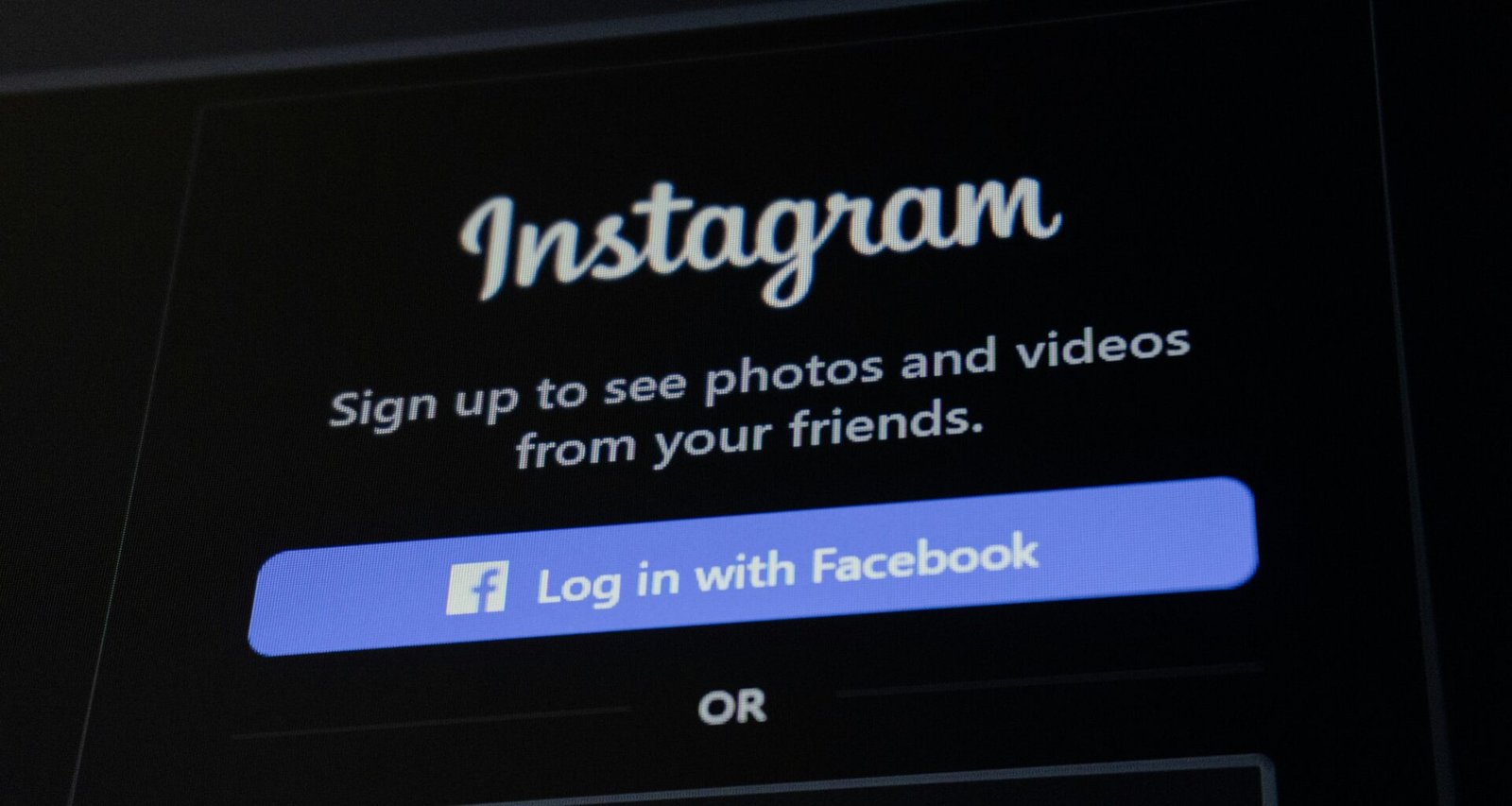 Smartphone zeigt Instagram-Anmeldebildschirm mit Facebook-Login-Option auf weißem Hintergrund.
