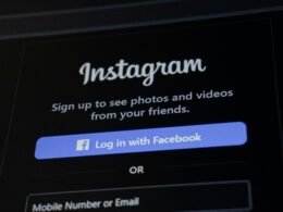 Smartphone zeigt Instagram-Anmeldebildschirm mit Facebook-Login-Option auf weißem Hintergrund.