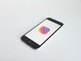 Instagram-Logo angezeigt auf einem space gray iPhone 6, fotografiert auf einem neutralen Hintergrund, Fokus auf App-Icon