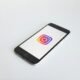 Instagram-Logo angezeigt auf einem space gray iPhone 6, fotografiert auf einem neutralen Hintergrund, Fokus auf App-Icon