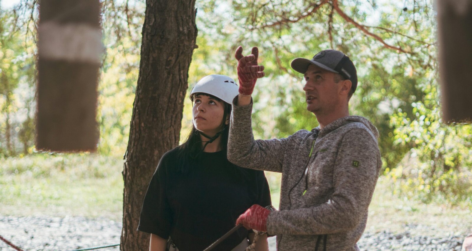 Eine Instruktorin zeigt einer jungen Frau bei einer Outdoor-Aktivität wichtige Techniken und Sicherheitsaspekte.