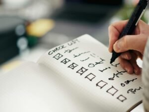 Jemand hakt Punkte auf einer Checkliste ab, um Aufgaben strukturiert zu verwalten und den Überblick zu behalten.