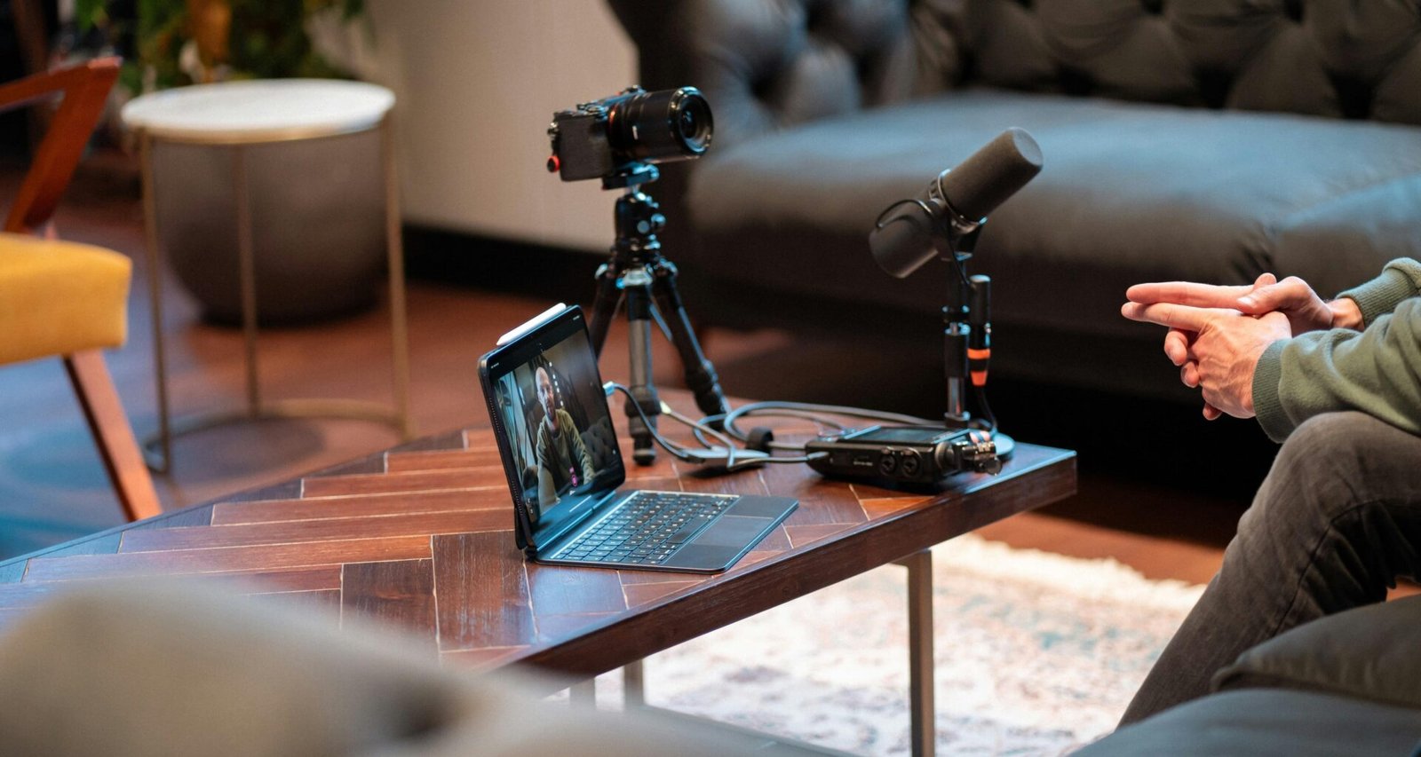 Kamera, Mikrofon und Laptop stehen auf einem Tisch und sind für Ton- und Videoaufnahmen professionell eingerichtet.