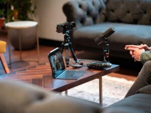 Kamera, Mikrofon und Laptop stehen auf einem Tisch und sind für Ton- und Videoaufnahmen professionell eingerichtet.
