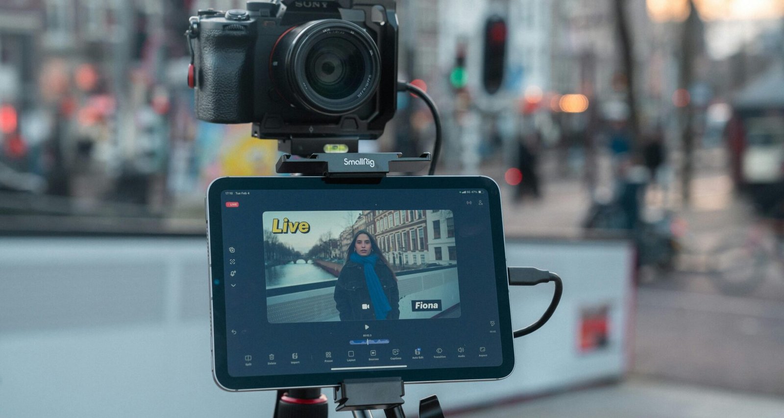 Kamera und Tablet auf Stativ filmen eine Stadtstraße mit Passanten und Autos als technische Aufnahme