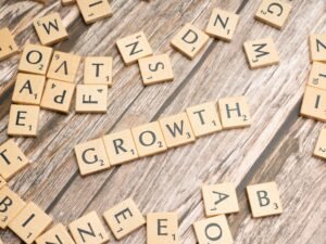 Scrabble-Buchstaben auf Holz bilden das Wort Growth – Symbol für Wachstum im Bereich Online-Marketing und digitale Geschäftsentwicklung.