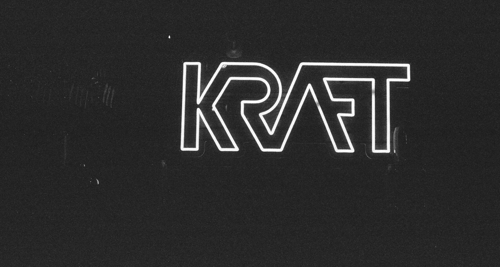 Das Kraft Logo vor schwarzem Hintergrund, zeigt minimalistisches Marken-Branding im Fokus des Bildes.