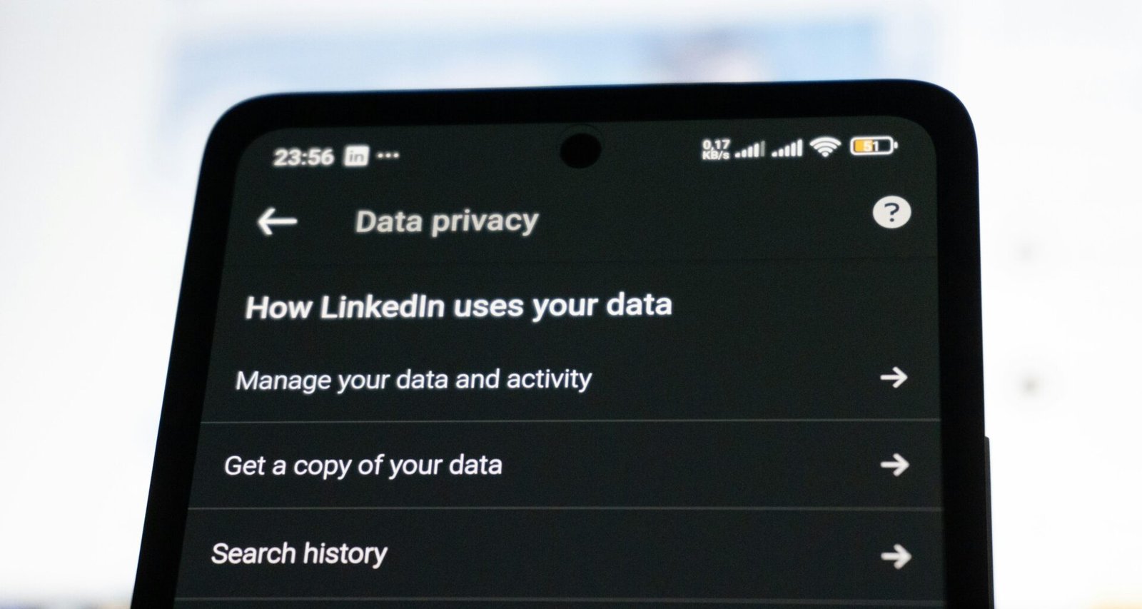 Smartphone mit geöffneter LinkedIn-App und sichtbaren Datenschutzeinstellungen in der Nahaufnahme