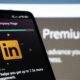 LinkedIn Premium Unternehmensseite wird auf einem Smartphone angezeigt, Nahaufnahme eines Displays mit Unternehmensprofil
