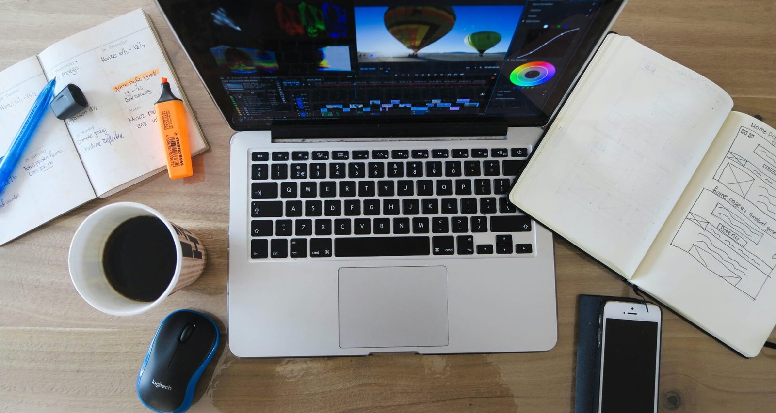 Ein MacBook Pro liegt geöffnet und eingeschaltet auf einem Schreibtisch und wird für berufliche oder kreative Aufgaben genutzt.