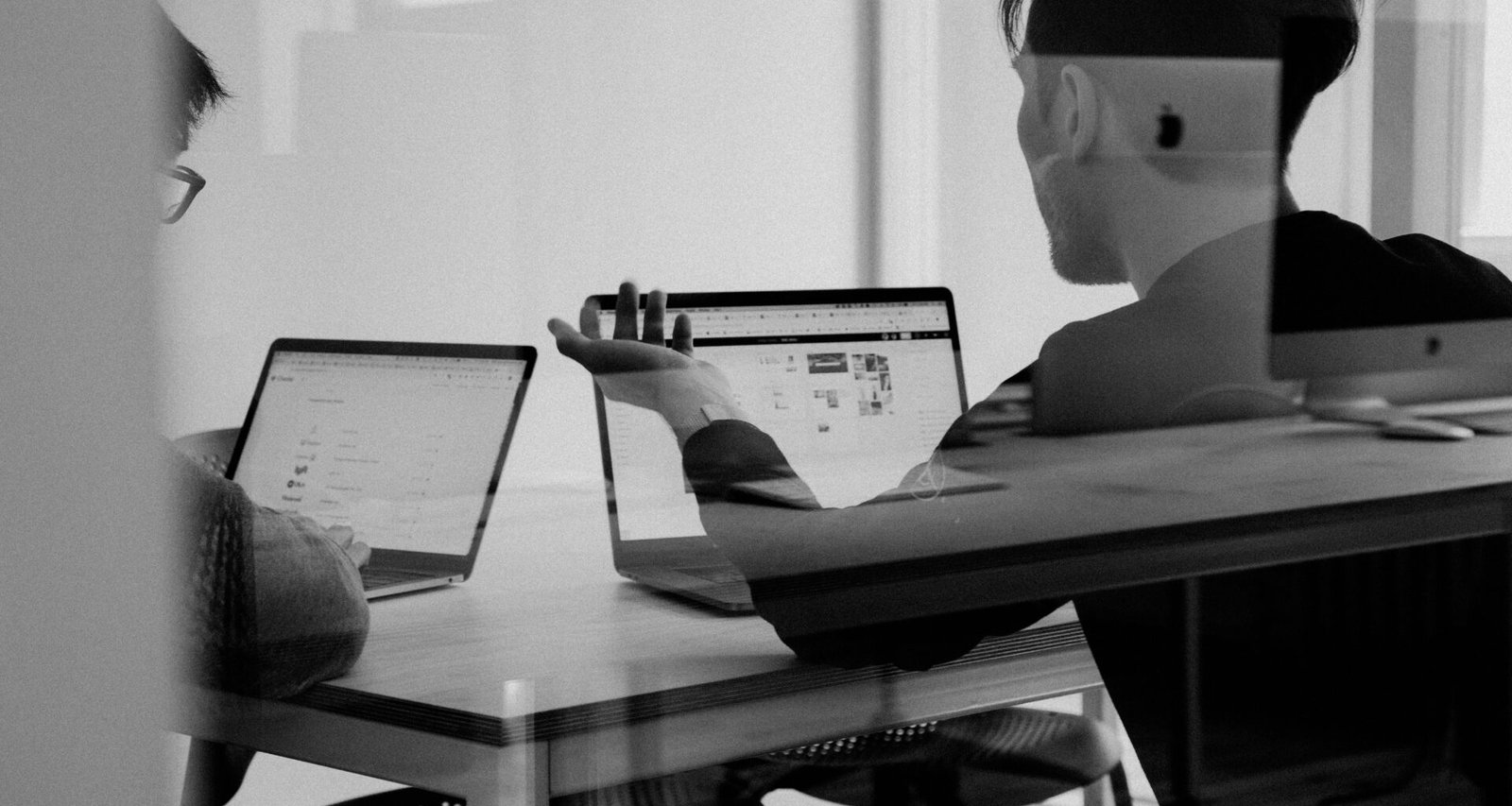 Mann arbeitet konzentriert an einem MacBook am Schreibtisch mit modernen Online-Marketing-Tools im Hintergrund.