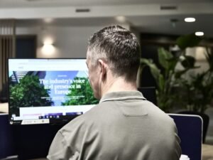 Mann arbeitet an einem Computer in einem modernen Büro, Schreibtisch mit Monitor und Büroausstattung