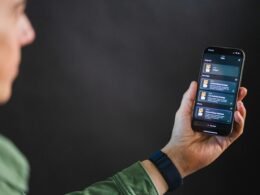 Mann hält ein Smartphone in der Hand, auf dessen Display eine App-Oberfläche zu sehen ist