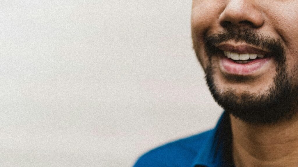 Ein Mann trägt ein blaues Polohemd und steht vor neutralem Hintergrund – geeignet für Themen rund um Business oder Technik.
